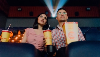 A couple watching a movie at a theater