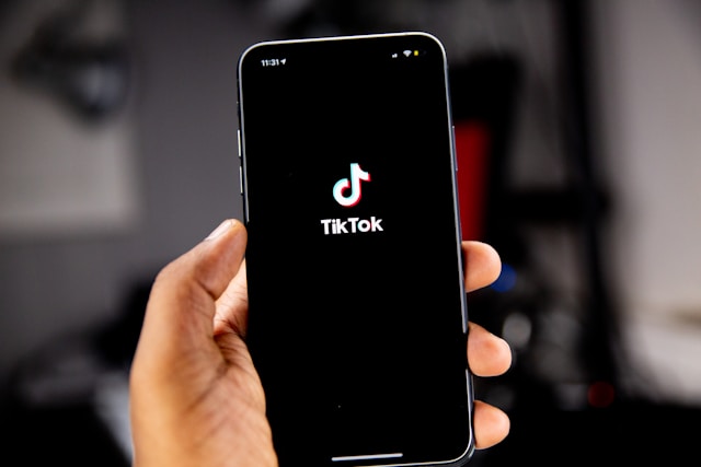 user holding smartphone with TikTok app